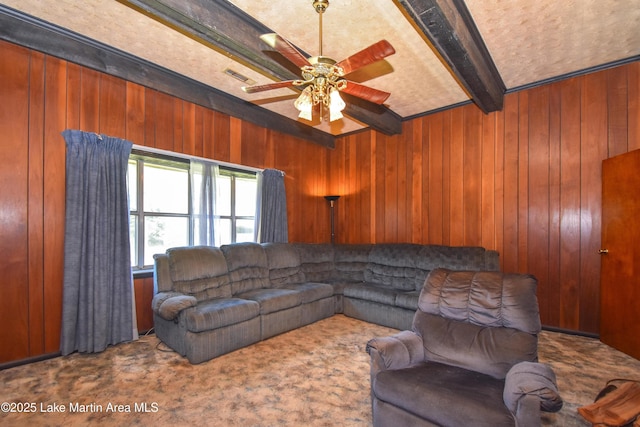 405 4th St, Tallassee, AL 36078 - living room with beamed ceiling, carpet, wooden walls, and a ceiling fan