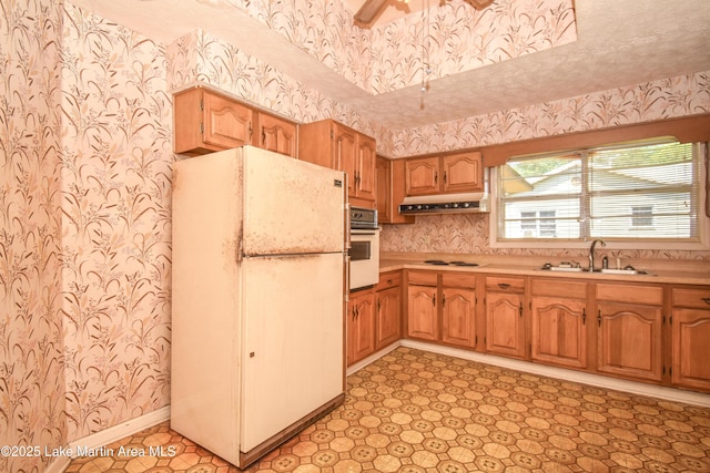 405 4th St, Tallassee, AL 36078 - kitchen with white appliances, wallpapered walls, under cabinet range hood, light countertops, and ceiling fan