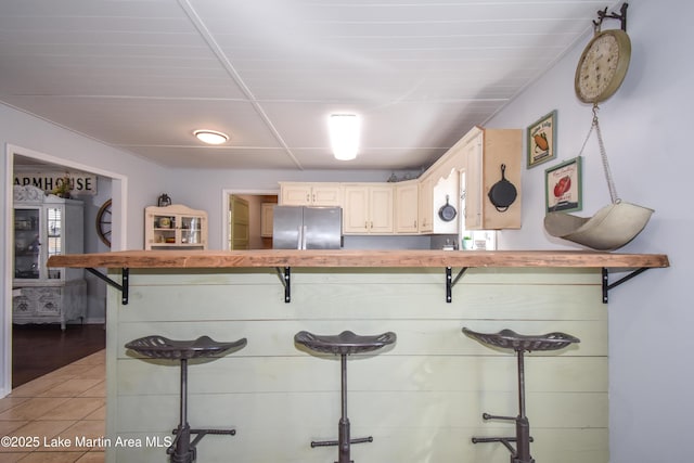 kitchen featuring stainless steel refrigerator and light tile patterned floors