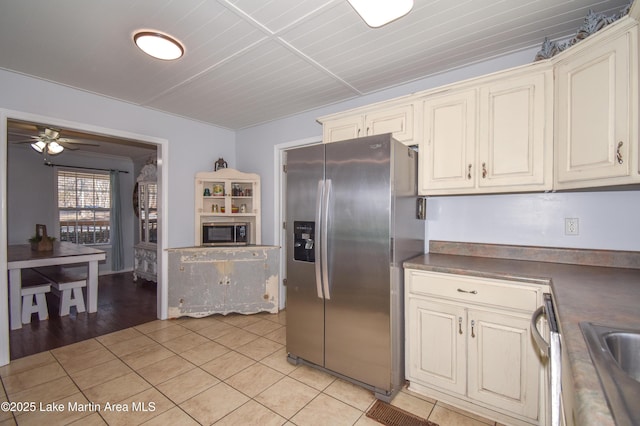 kitchen featuring appliances with stainless steel finishes, light tile patterned floors, ceiling fan, and cream cabinetry