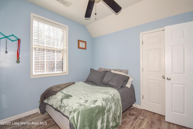 bedroom with hardwood / wood-style flooring, vaulted ceiling, and ceiling fan