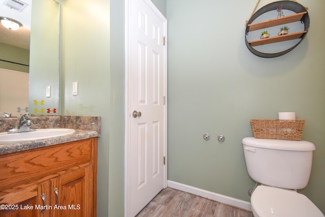 bathroom featuring hardwood / wood-style flooring, vanity, and toilet