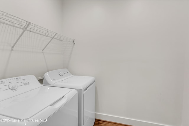 laundry room featuring washer and clothes dryer and hardwood / wood-style floors