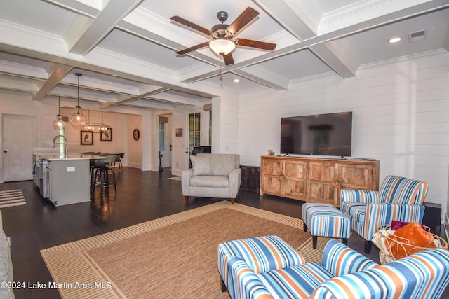 living room featuring beam ceiling, ceiling fan, dark wood-type flooring, coffered ceiling, and wooden walls