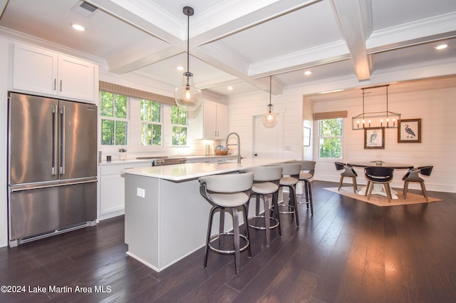 kitchen with white cabinetry, high end fridge, an island with sink, and hanging light fixtures