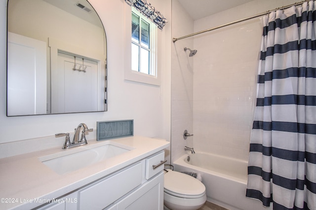 full bathroom featuring shower / bath combination with curtain, toilet, and vanity