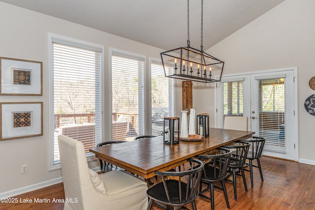 dining room featuring dark wood-type flooring, french doors, baseboards, and lofted ceiling