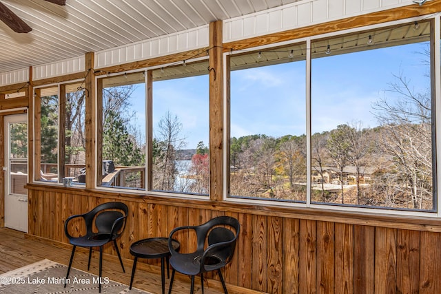 unfurnished sunroom featuring a ceiling fan and a healthy amount of sunlight