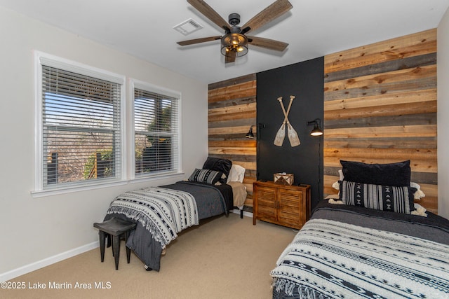 bedroom featuring visible vents, light carpet, a ceiling fan, wood walls, and baseboards