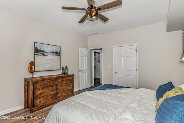 bedroom featuring a ceiling fan, baseboards, and wood finished floors