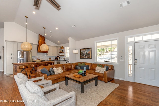 living area featuring recessed lighting, visible vents, high vaulted ceiling, and wood finished floors