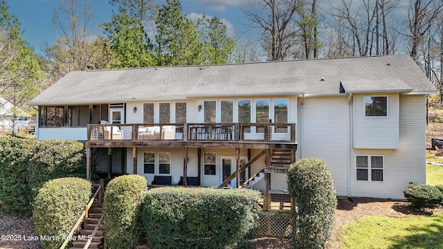 rear view of house featuring stairway, a shingled roof, and a deck