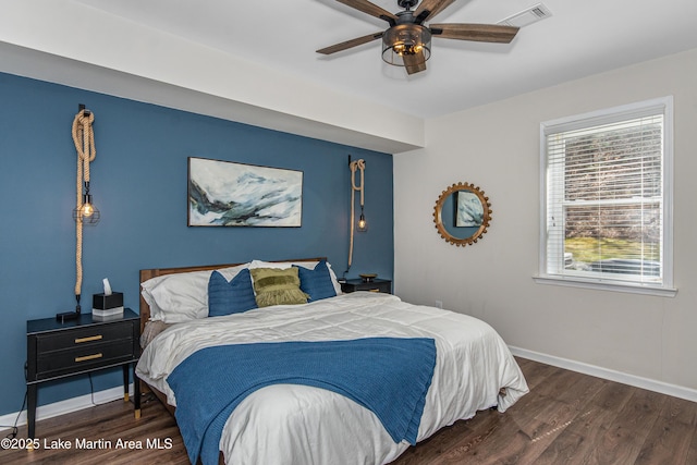 bedroom with visible vents, baseboards, wood finished floors, and a ceiling fan