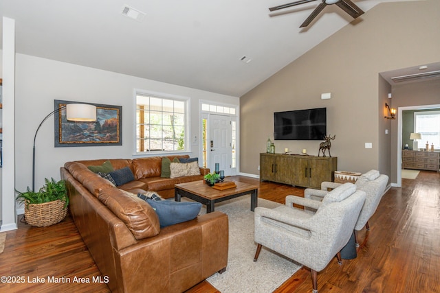 living room featuring dark wood finished floors, visible vents, high vaulted ceiling, and baseboards