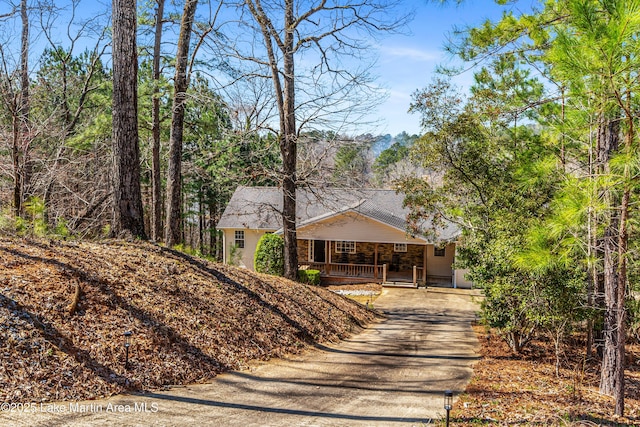 single story home featuring roof with shingles, covered porch, and driveway