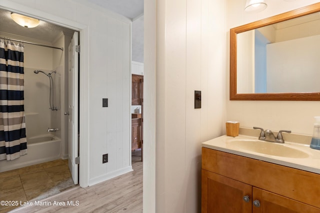 full bathroom featuring shower / bathtub combination with curtain, wood finished floors, ornamental molding, and vanity