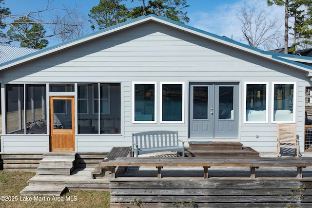 bungalow-style house featuring a sunroom, a deck, and entry steps