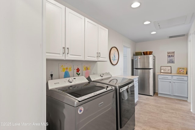 laundry area featuring visible vents, attic access, recessed lighting, cabinet space, and washer and dryer