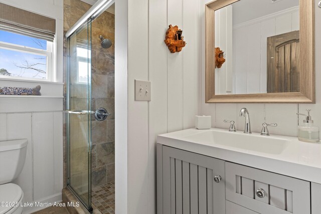 full bath with vanity, toilet, and a shower stall