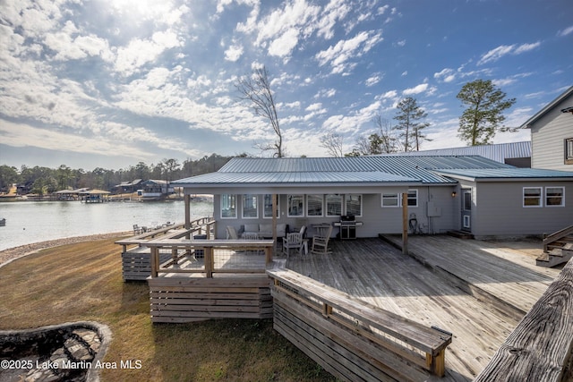 wooden deck with area for grilling and a water view