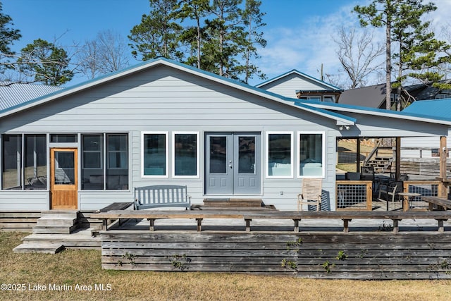 view of front of house with entry steps, a wooden deck, and a sunroom