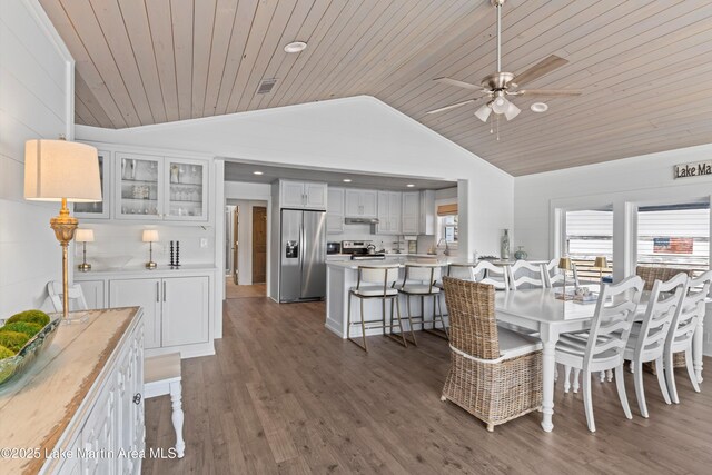 dining area featuring plenty of natural light, lofted ceiling, and wood finished floors