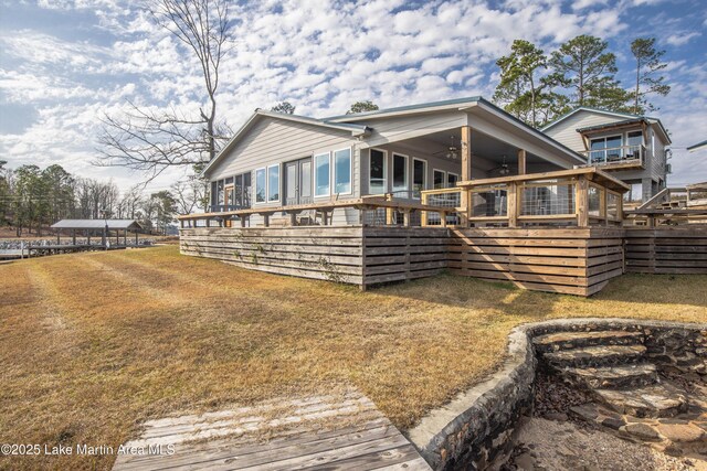 rear view of property featuring a wooden deck, fence, a lawn, and ceiling fan