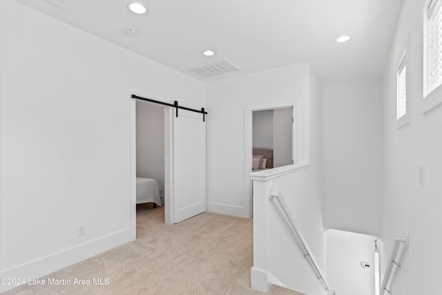 interior space featuring light carpet and a barn door