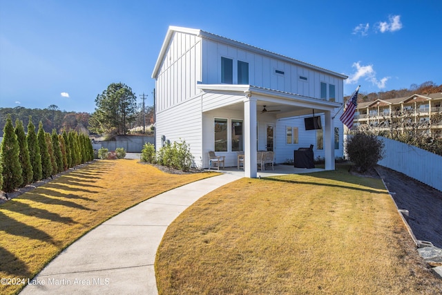 rear view of house featuring a patio, ceiling fan, and a lawn