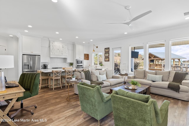 living room with ceiling fan, wood-type flooring, and ornamental molding