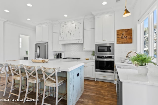 kitchen with appliances with stainless steel finishes, dark hardwood / wood-style flooring, sink, white cabinetry, and hanging light fixtures