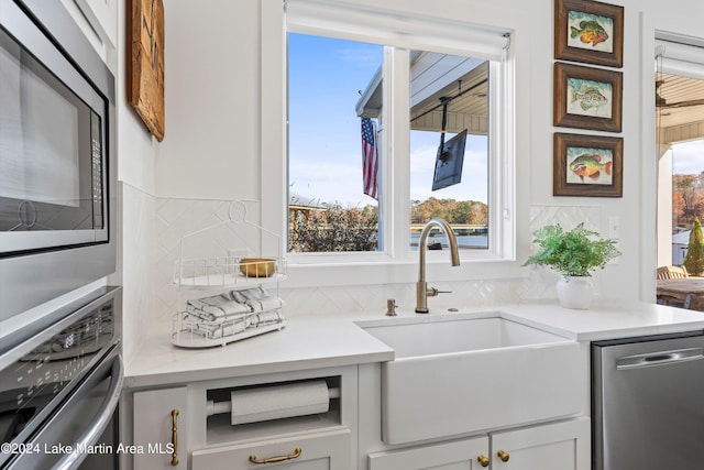 kitchen featuring appliances with stainless steel finishes, white cabinetry, sink, and a wealth of natural light