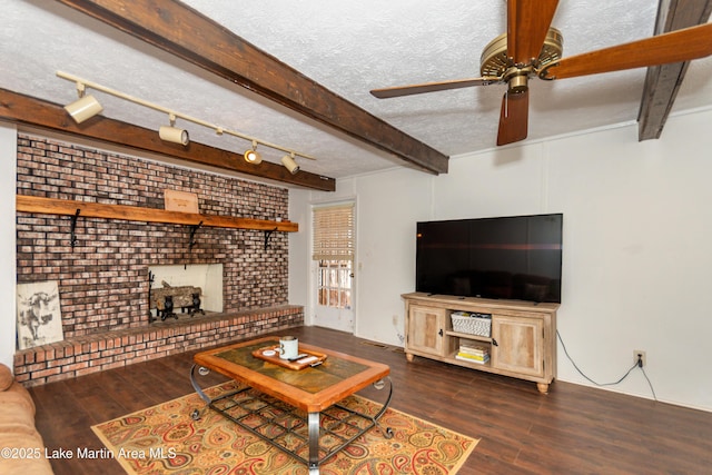 living room with ceiling fan, a textured ceiling, dark hardwood / wood-style floors, and beam ceiling