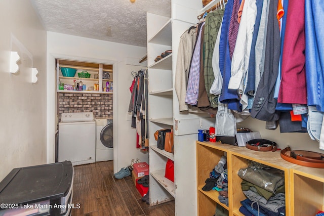 spacious closet featuring washing machine and dryer and dark hardwood / wood-style flooring