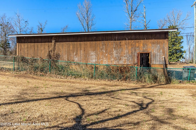 view of side of home featuring a lawn and an outdoor structure