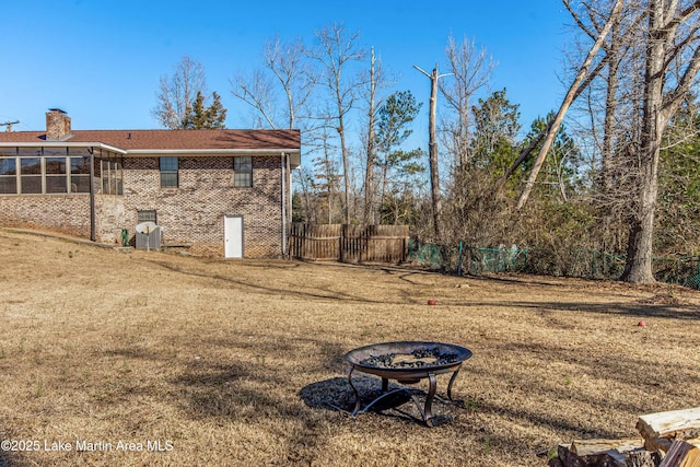 view of yard with an outdoor fire pit and a sunroom