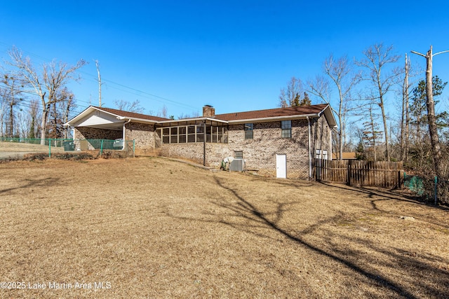 back of house featuring a sunroom and a lawn