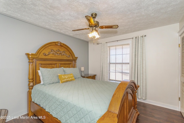 bedroom with a textured ceiling, ceiling fan, and dark hardwood / wood-style flooring