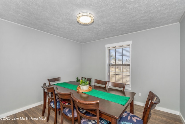 dining area with dark wood-type flooring and a textured ceiling