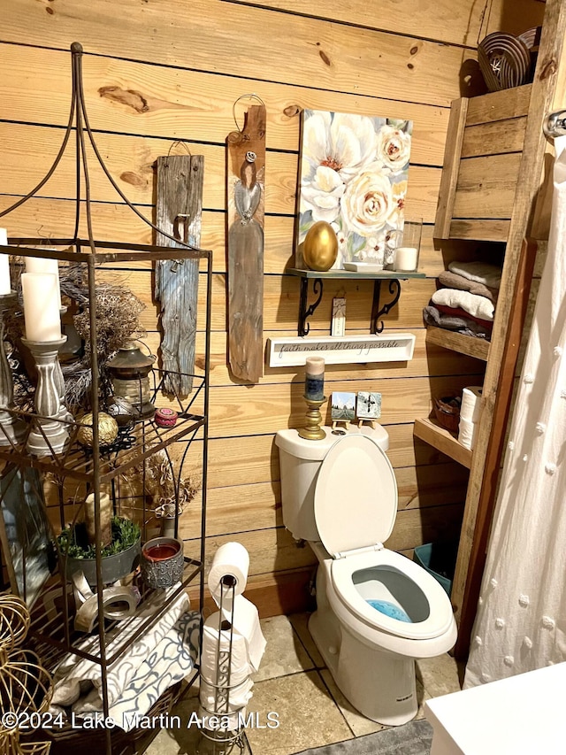 bathroom featuring wood walls and toilet