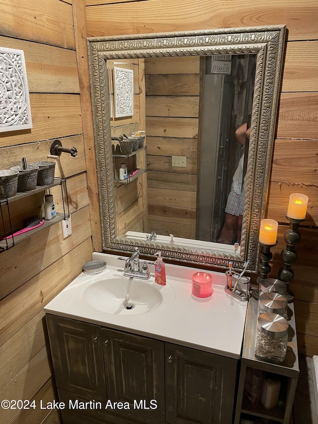 bathroom featuring vanity and wood walls