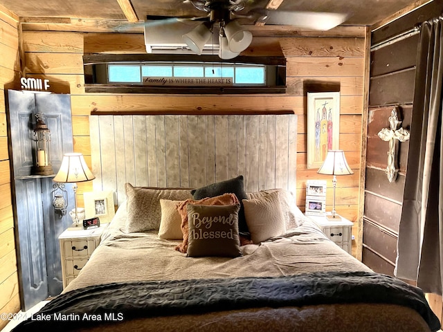 bedroom with ceiling fan and wood walls