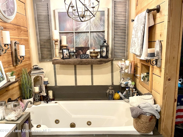 bathroom featuring wood walls, a bath, and an inviting chandelier