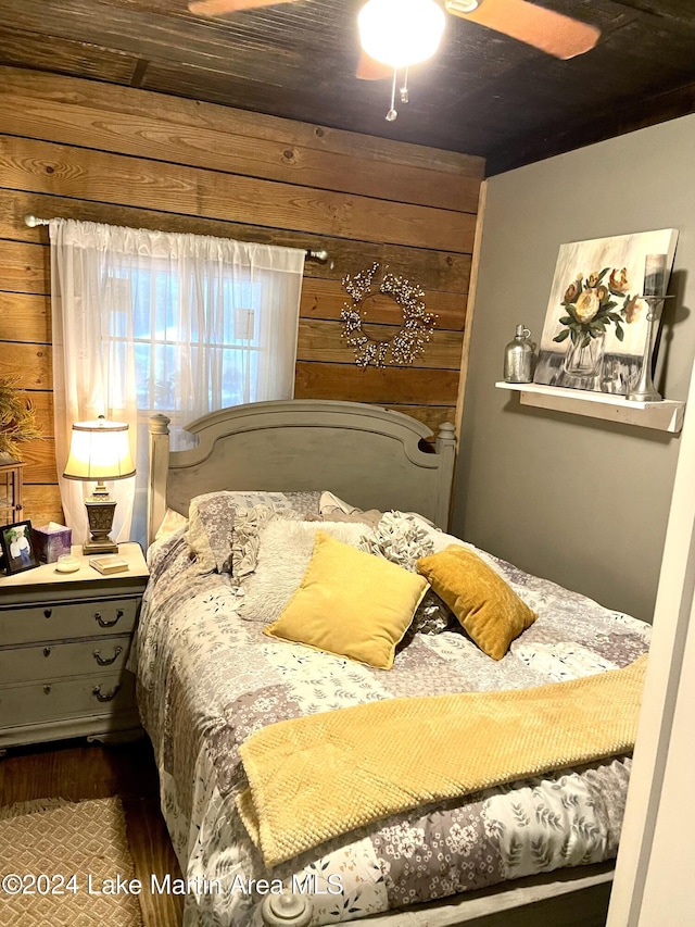 bedroom with wooden walls, ceiling fan, and wooden ceiling