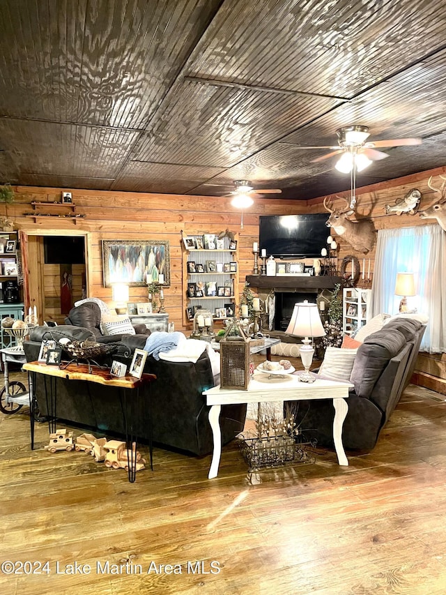 living room with wooden walls, hardwood / wood-style floors, ceiling fan, and wood ceiling