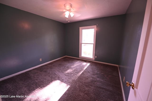 spare room featuring baseboards, a ceiling fan, and carpet floors