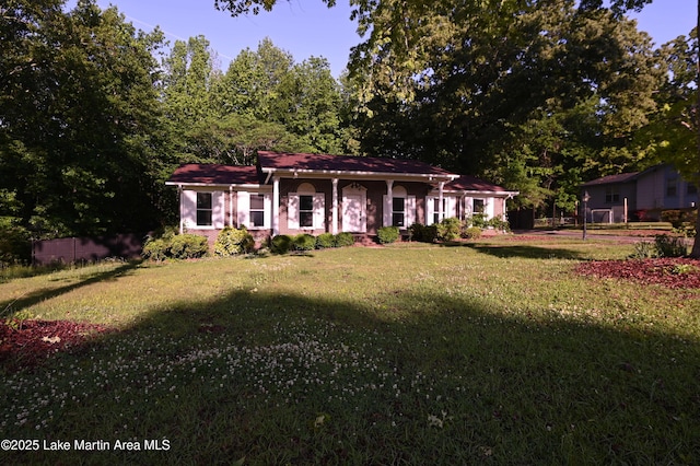 view of front of home with a front yard and fence