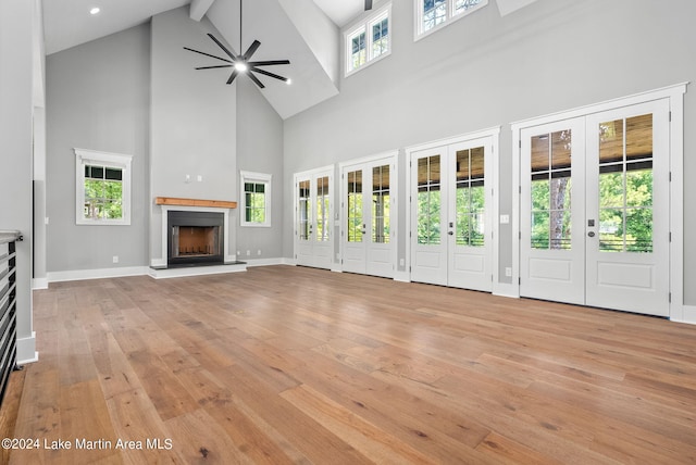 unfurnished living room featuring french doors, high vaulted ceiling, and a healthy amount of sunlight