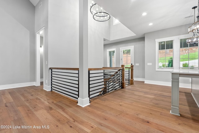 interior space with a high ceiling, light hardwood / wood-style floors, and a notable chandelier