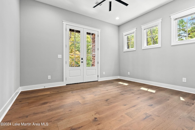 unfurnished room featuring plenty of natural light, wood-type flooring, and french doors